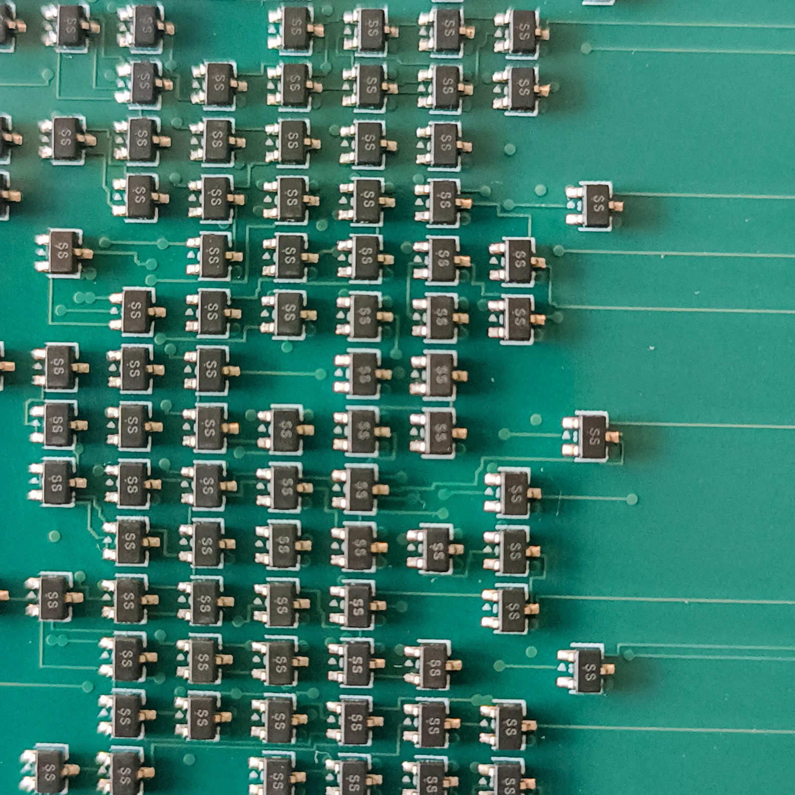 Close-up of the transistor array: rows of SOT-323
         packages, all marked SS, all in the same orientation, each with a silkscreen triangle
         marking pin 1.
